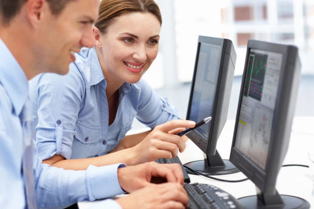 Businessman and woman working on computers